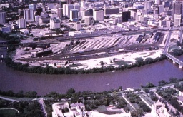 Photo aérienne de la gare de triage; on y voit une rivière au premier plan et de grands immeubles de bureaux à l’arrière-plan.