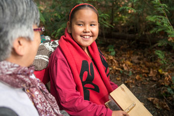 Une fillette d’une Première Nation locale et sa grand mère font une démonstration de l’art traditionnel du tricot au camping McDonald. 