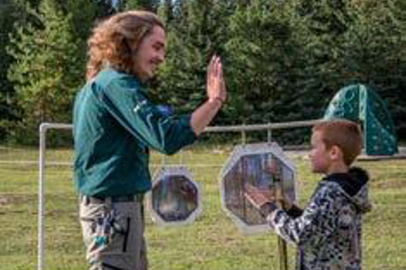 Un homme et un jeune garçon se donnent un high-five dans un champ.