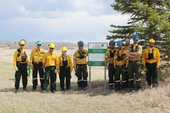 Photo de dix personnes vêtues d’équipement de protection dans un paysage naturel.