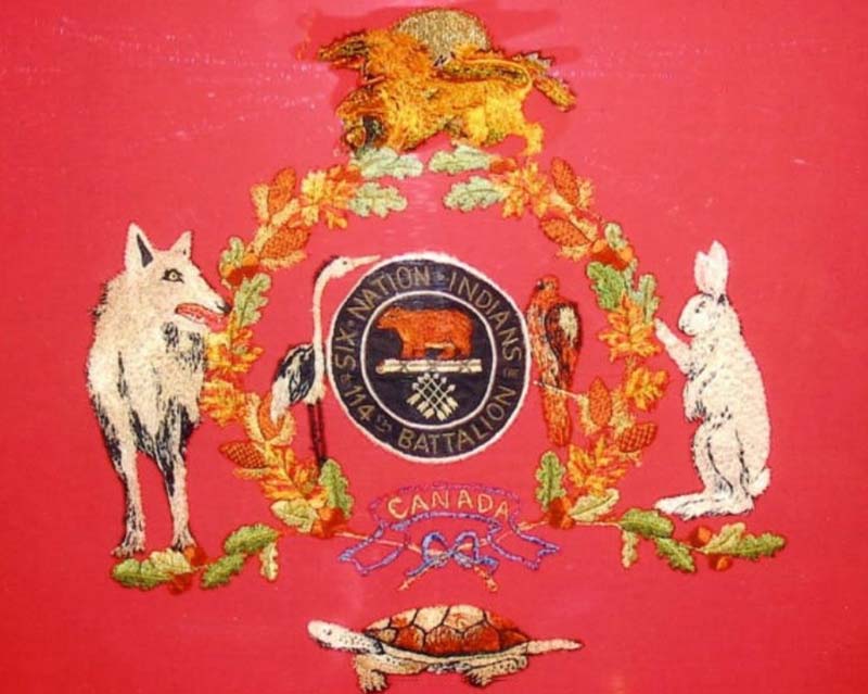Drapeau de couleur rouge brodé avec des images et des symboles d'animaux et de plantes