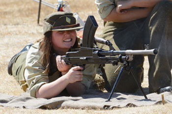 Interprète féminine en uniforme de la Seconde Guerre mondiale faisant une démonstration de tir de la mitrailleuse légère Bren.