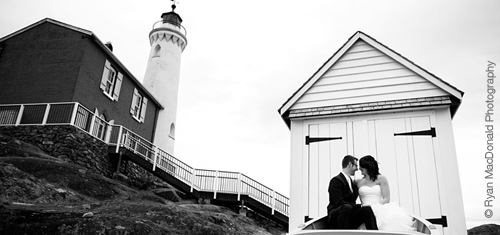 A bride and groom sitting in from of Fisgard Lighthouse.
