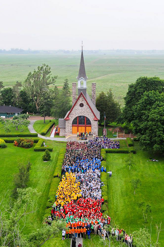 Des centaines de jeunes athètes sont debout devant l'Église-souvenir