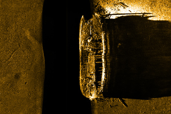 Image de la coque du navire sur un fond plus foncé. Une bonne portion du pont est manquant, révélant des poutres et le pont inférieur.