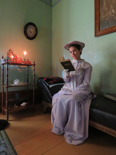 一個穿著歷史服裝的女人在看書