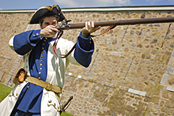 Un soldat français s'apprête à tirer au mousquet au Fort-Chambly