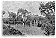 Photo noir et blanc de la porte, du pont, de la douve et de la végétation environnante du fort Lennox.