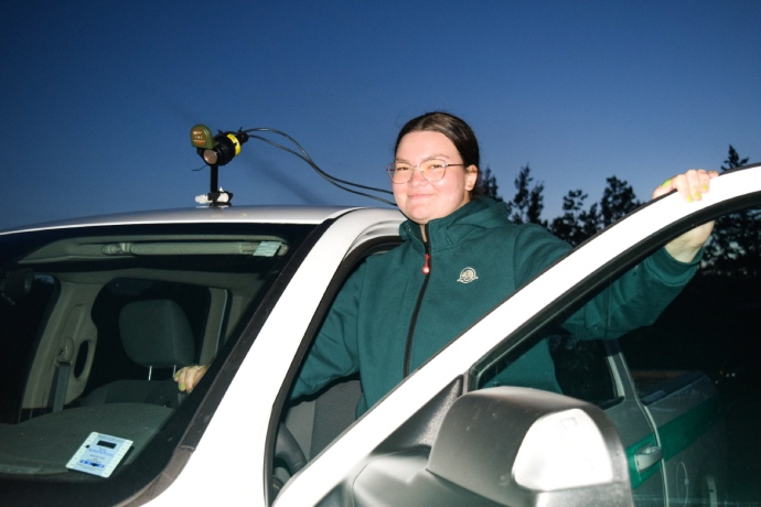 Un employé de Parcs Canada sourit en entrant dans le véhicule qui est équipé d’un appareil de surveillance acoustique.