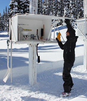 Un employé de Parcs Canada ouvre la station météorologique de l’abri Stevenson.