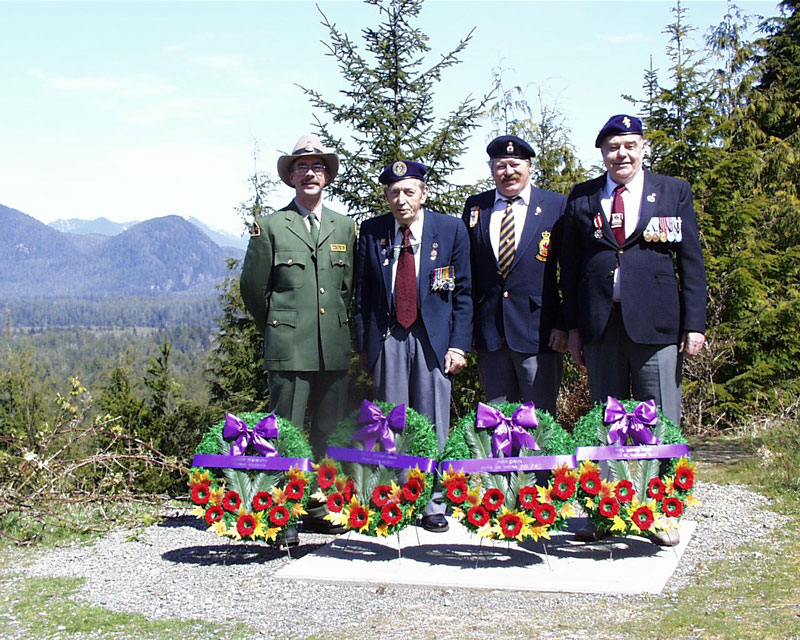 Un garde de parc et des vétérans de la Corée se tiennent sur la colline Radar, des couronnes sont posées devant eux
