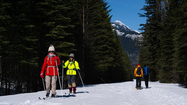 Des skieurs de fond et des raquetteurs sont de chaque côté d’un sentier d’hiver polyvalent.