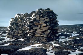Des pierres sont empilées sur le sol rocheux pour former un cairn.