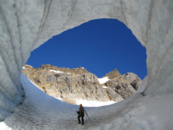 Un spécialiste de sécurité en montagne de Parcs Canada se déplace sur un glacier encordé en sécurité. 