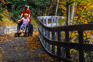 Un visiteur en fauteuil roulant est guidé le long du sentier du lac Freshwater