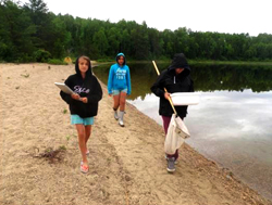 De gauche à droite, Kalysta Collins Bouchard, Ocean Cherneski et Baily O'Conner, à la recherche d’espèces envahissantes au lac Louie