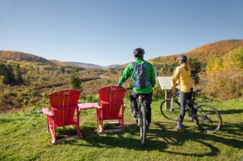 Deux cyclistes prennent une pause pour observer le paysage d’automne
