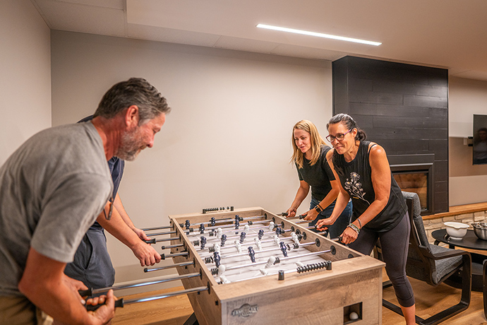 Des visiteurs jouent au babyfoot au sous-sol.