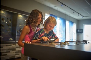 Deux petites filles observent des fossiles avec une loupe