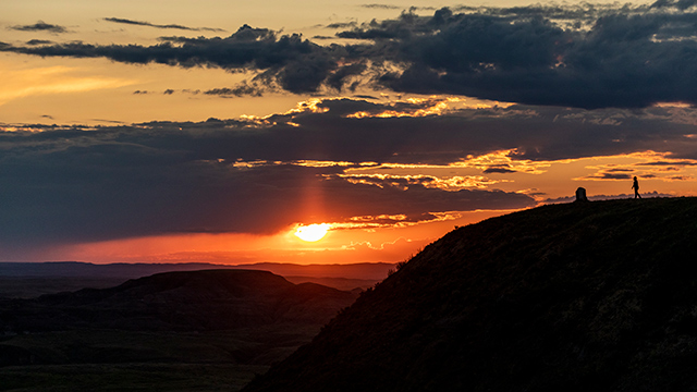 Scènes du coucher de soleil le long de la Promenade des Badlands du bloc est dans le parc national des Prairies.