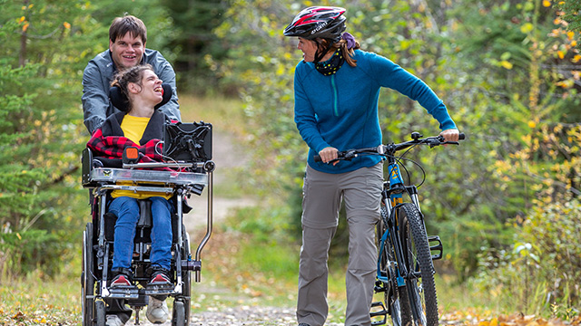 Des visiteurs empruntent les sentiers accessibles en vélo et en fauteuil roulant du sentier Red Deer sur le terrain de camping Beaver Glen, au parc national de Prince Albert. 