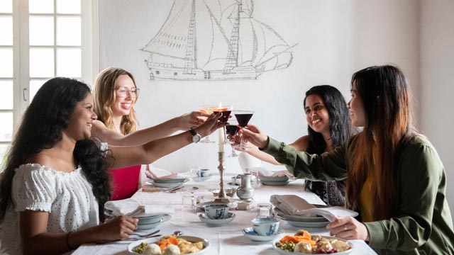 Quatre adultes à table pour souper à la forteresse de Louisbourg.