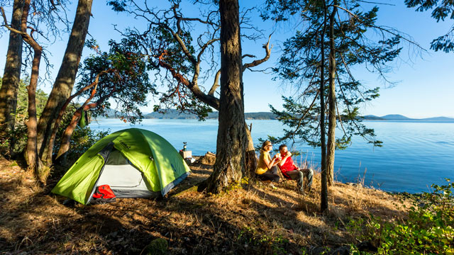 Deux campeurs relaxent en bordure de l’eau au camping de la Pointe Arbutus dans les îles Gulf.