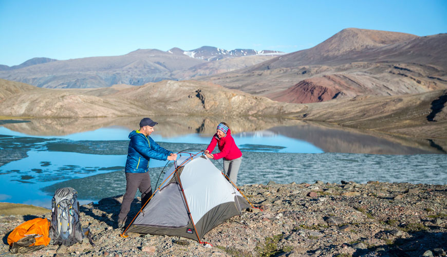 Deux visiteurs établissent leur camp en bordure de l'eau dans le secteur Omega Lakes.