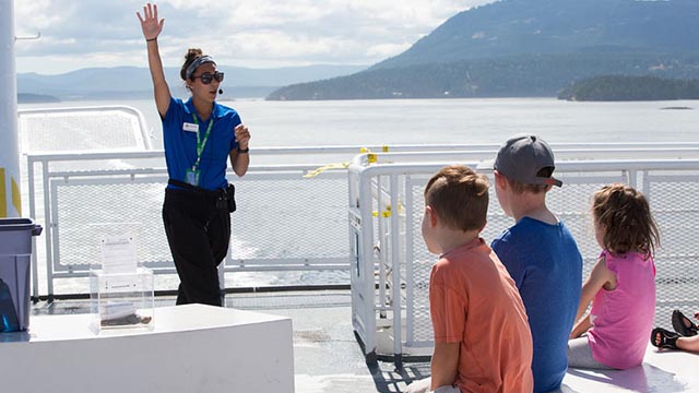 Une employée de BC Ferries parle avec trois enfants