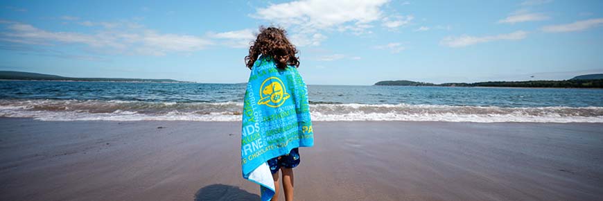 Une jeune fille avec sa serviette sur la plage de la Baie North.