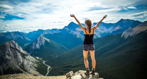 Une jeune femme apprécie le sommet de Sulphur Skyline, les bras en croix.