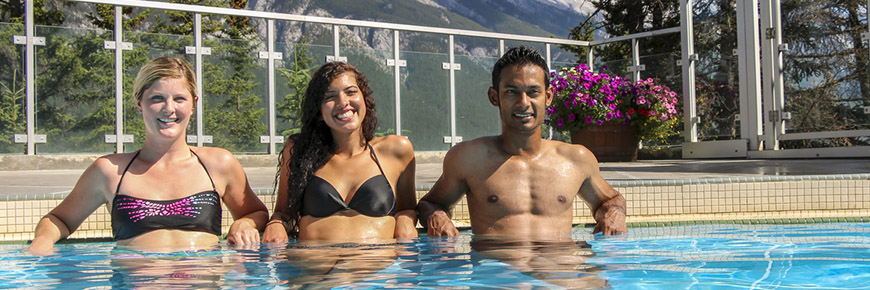 Trois adultes dans la piscine d’eau chaude des sources thermales Upper Hot Springs de Banff