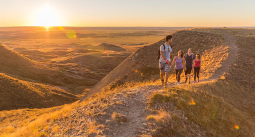 De jeunes adultes en randonnée sur le sentier de Butte-70-Mile du bloc Ouest, dans le parc national des Prairies.